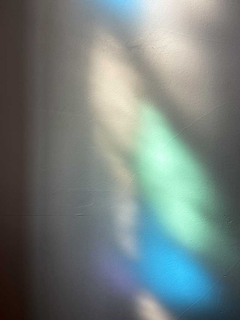 Claudia Weber, exhibition at former Carl Street Studios, Coach House 1, Light is coming through the colored glass and reflects on the adjacent wall in shades of blue, green, and purple